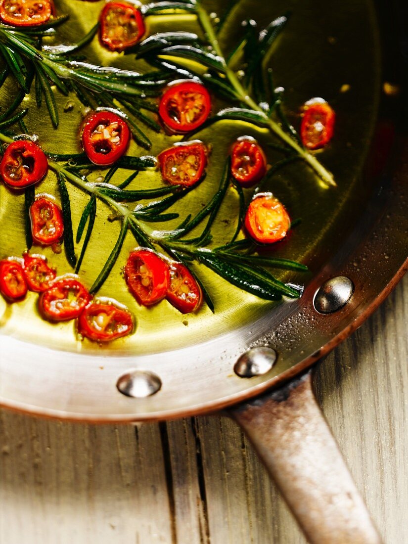 Chilli rings and rosemary in a pan with olive oil