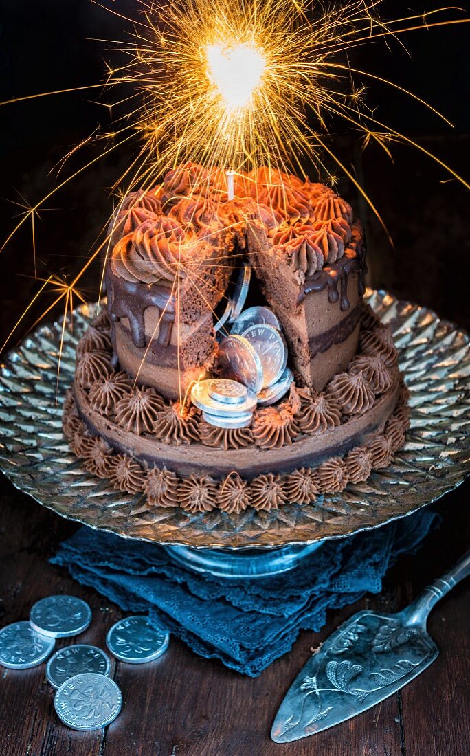 Sliced chocolate cake with silver and sparklers for New Year