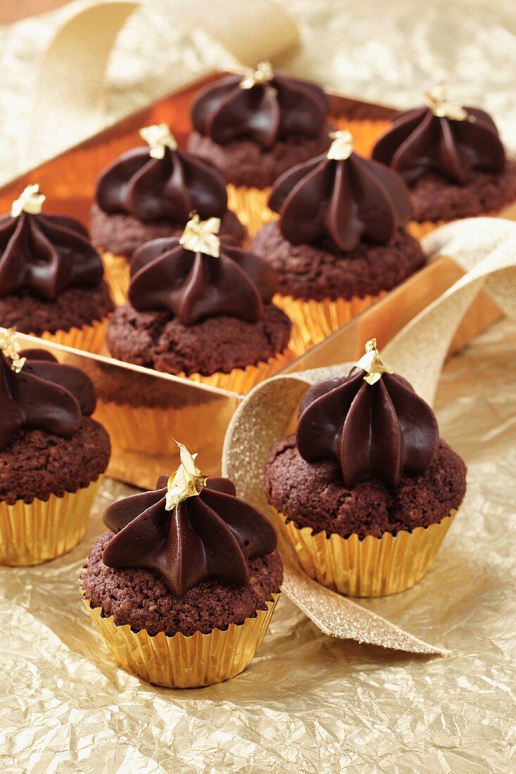 Mini-Schokoladen-Cupcakes mit Blattgold in goldfarbener Schachtel