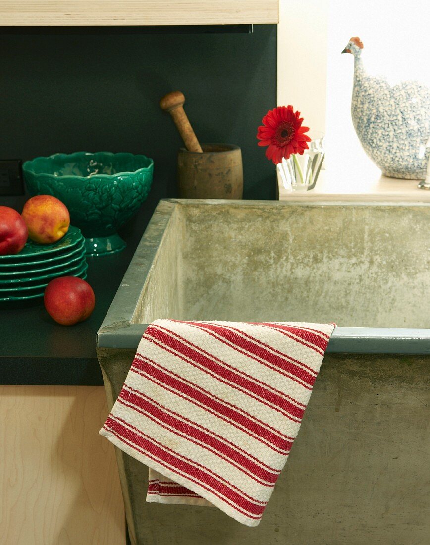 Red-and-white-striped tea towel draped over the edge of a stone sink