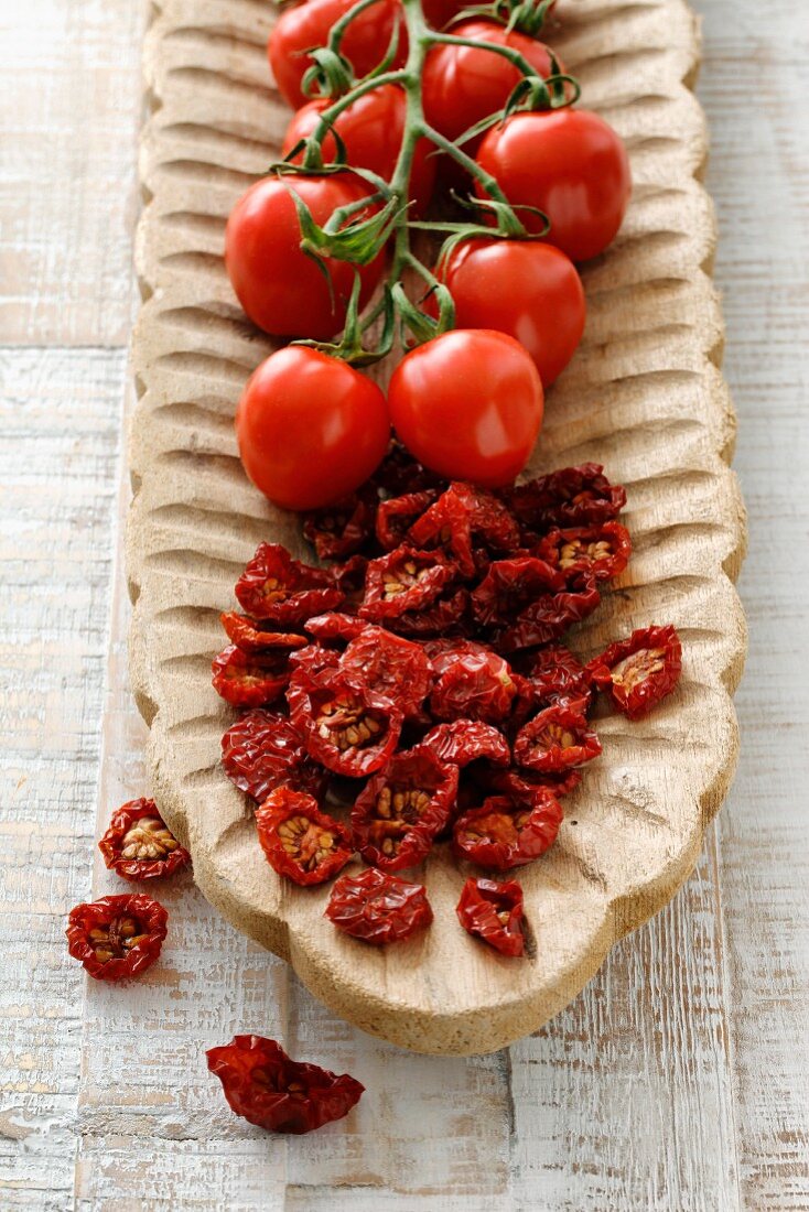 Dried and fresh cherry tomatoes in a wooden bowl