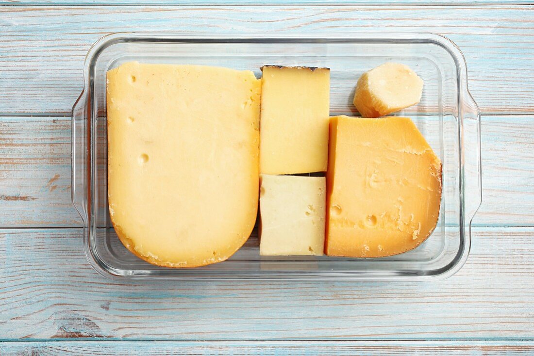 Various types of cheese (Gouda, Comte, Greyerzer, Parmesan) in a glass dish