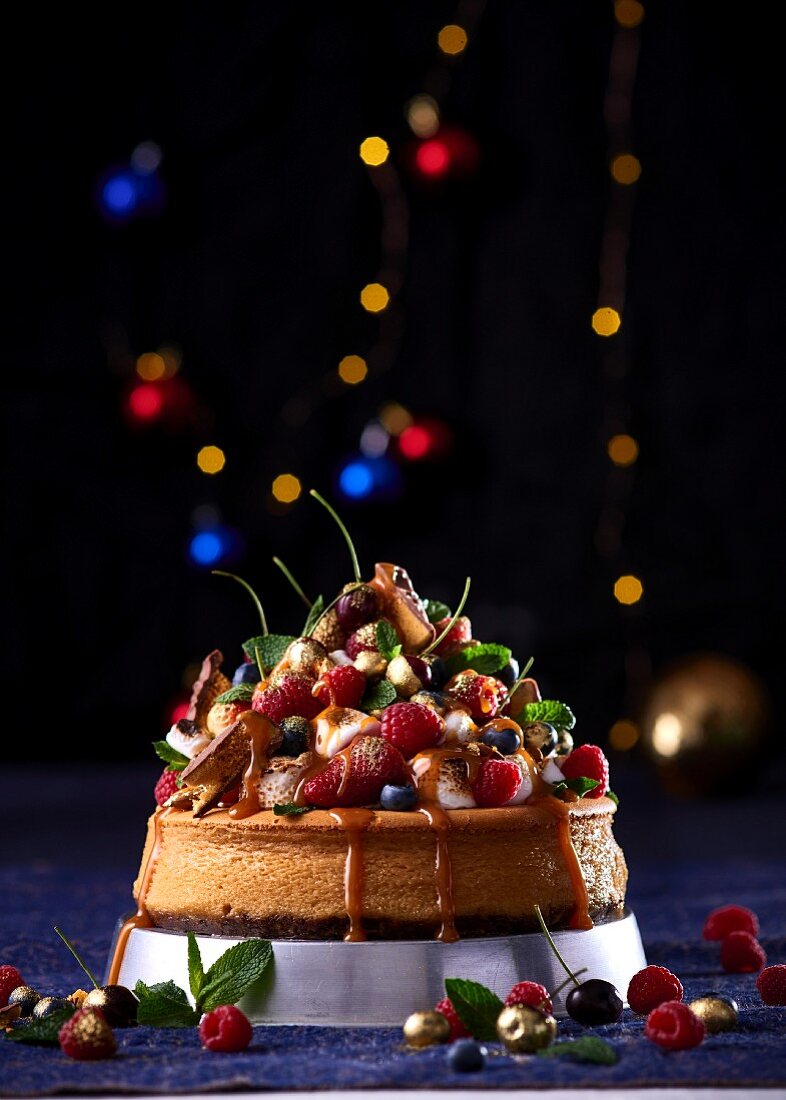 Cheesecake mit weisser Schokolade, Ingwerkeksboden und Beeren-Marshmallow-Dekoration