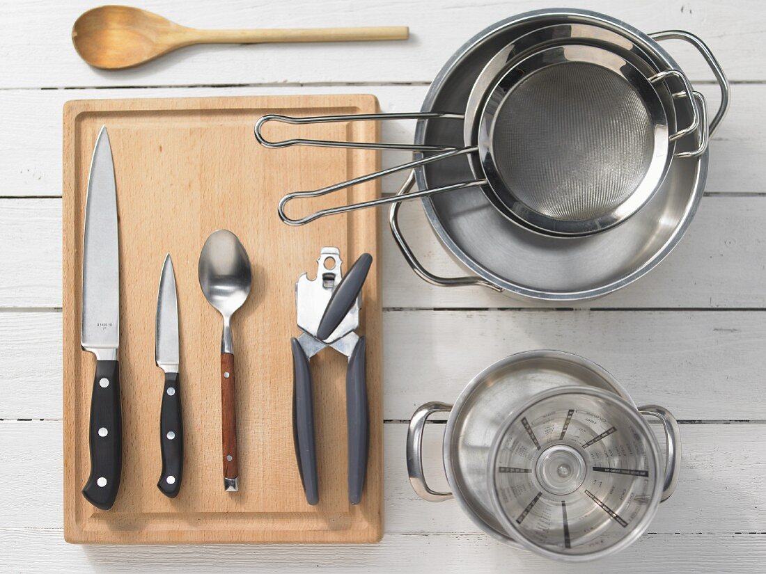 Various kitchen utensils: pots, sieves, measuring cups, can openers, knives