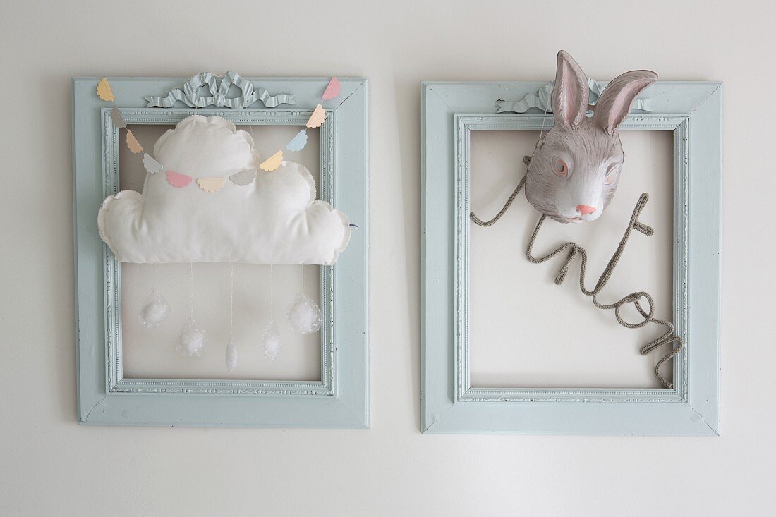 Two blue frames decorated with lettering, cloud mobile and rabbit mask