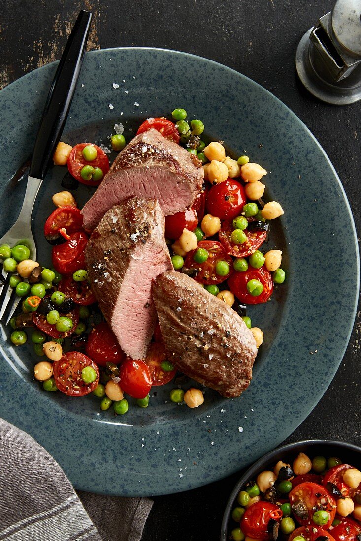 Lamb fillet with fried tomatoes with peas and chickpeas