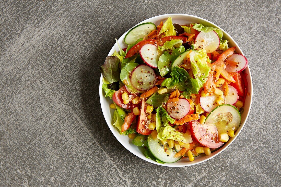 Gemischter Salat mit Radieschen, Möhren, Mais, Tomaten und Gurken
