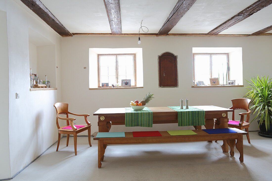 Wooden dining set with colourful felt seat cushions in dining room