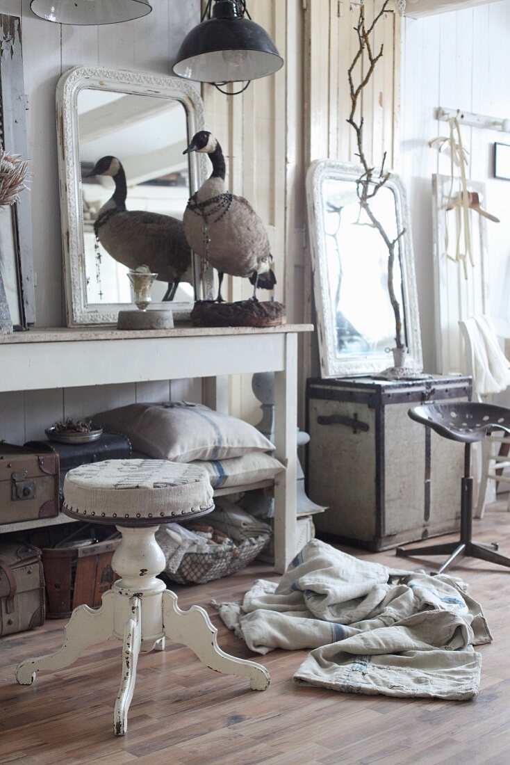 Stuffed goose and vintage pieces on console table