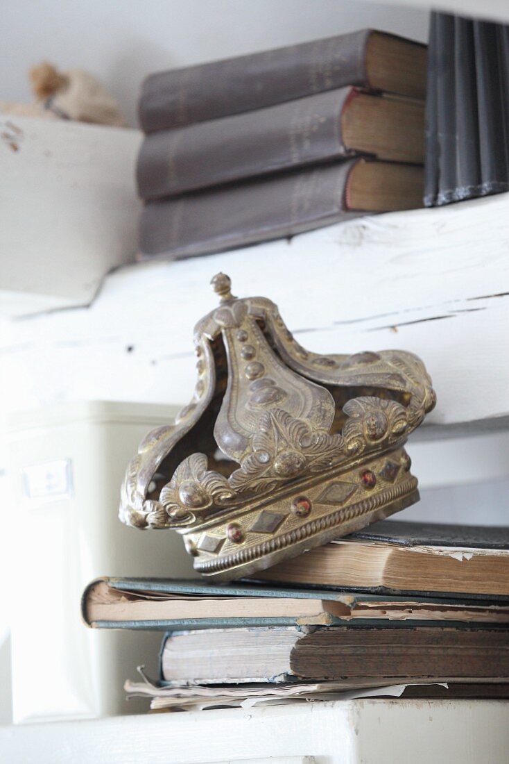 Antique metal crown on stock of old books