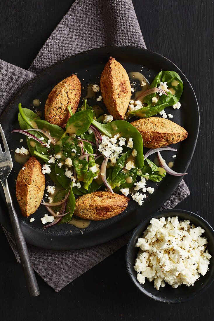 Spinach salad with cauliflower falafel and feta