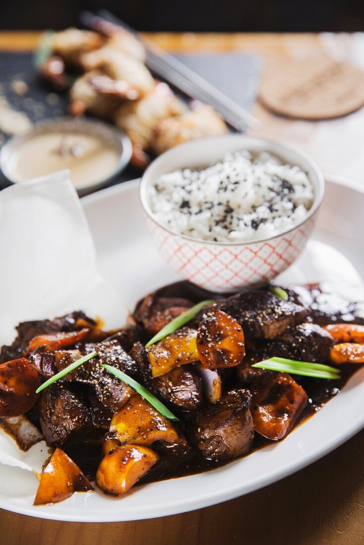 Asian dish - beef in black pepper sauce with vegetables and rice