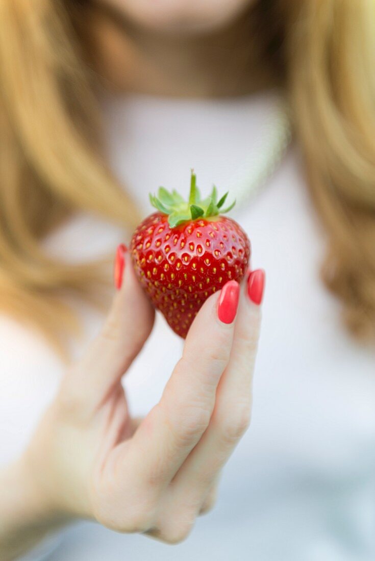 A woman holding strawberries