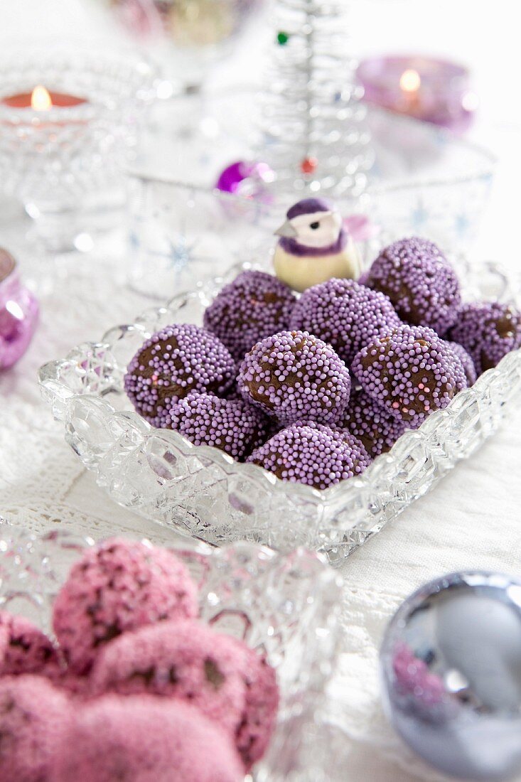 Schokoladenpralinen mit lila Zuckerperlen zu Weihnachten