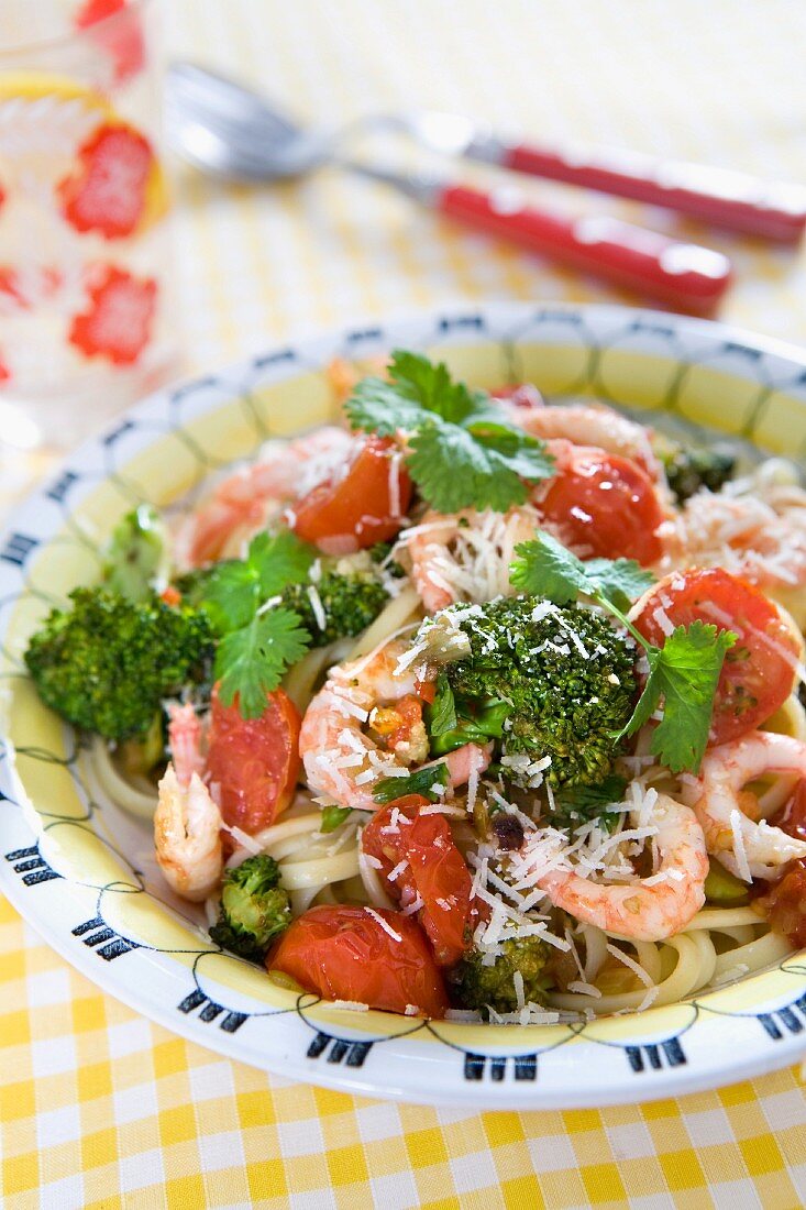 Pasta with shrimps, oven-baked cherry tomatoes, broccoli, fresh coriander and grated parmesan