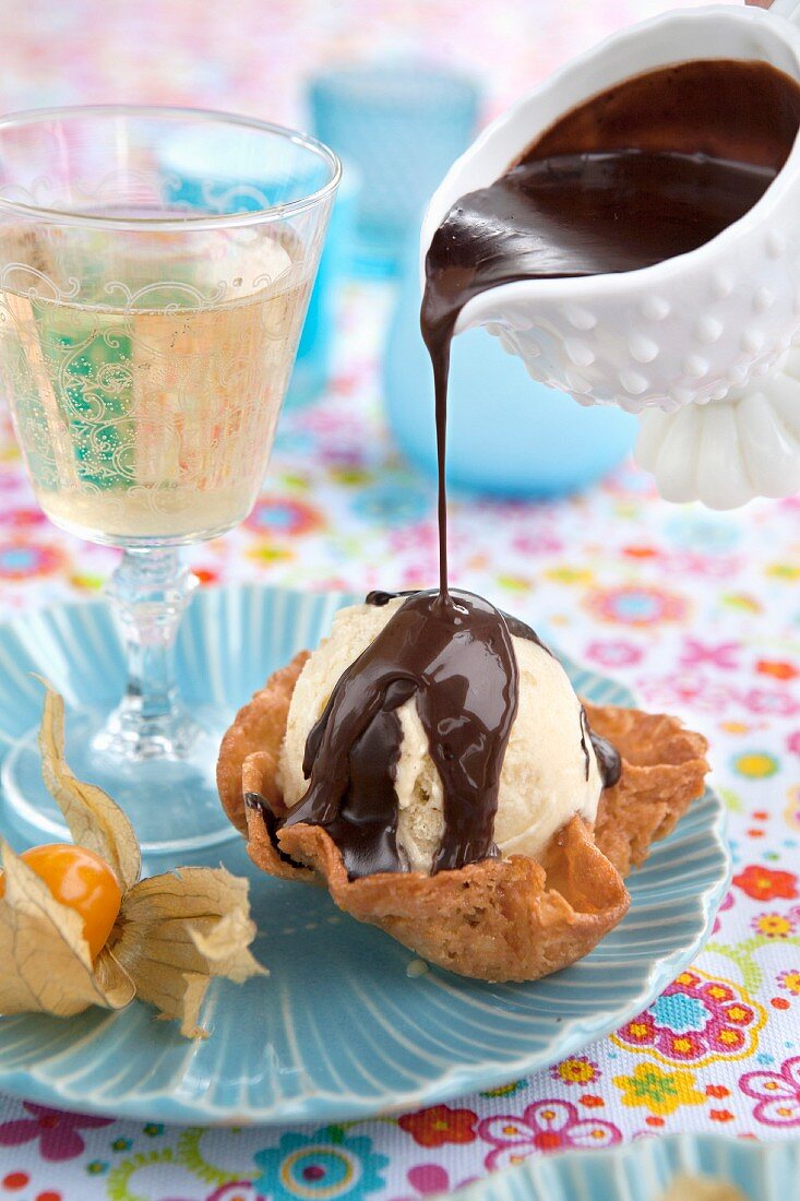 Dessert: vanilla ice cream in baked butterscotch basket with chocolate sauce. Sparkling wine