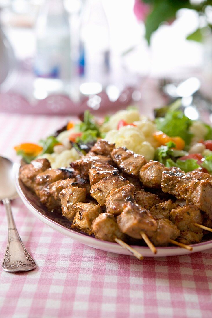 Grilled chicken skewers with lettuce, cauliflower and peppers