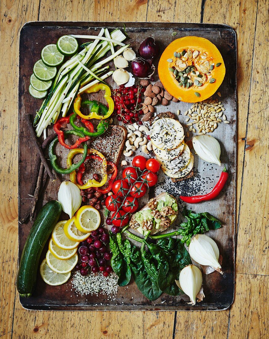 Verschiedene Gemüsesorten, Obst und Nüsse auf altem Backblech