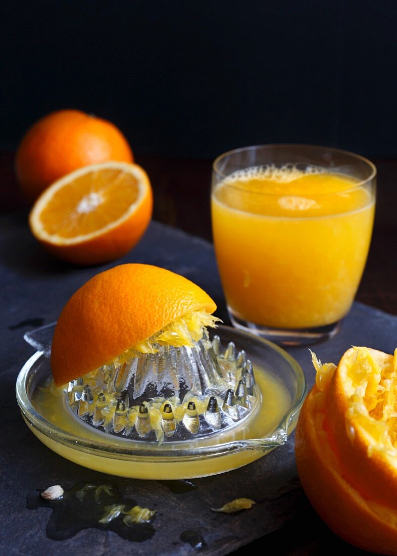 Frisch gepresste Orangen und ein Glas Orangensaft
