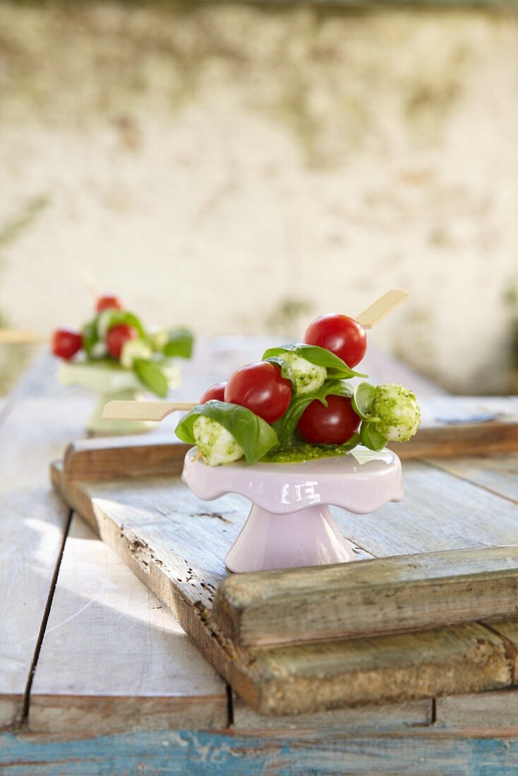 Cherry tomatoes and mozzarella balls on skewers with basil
