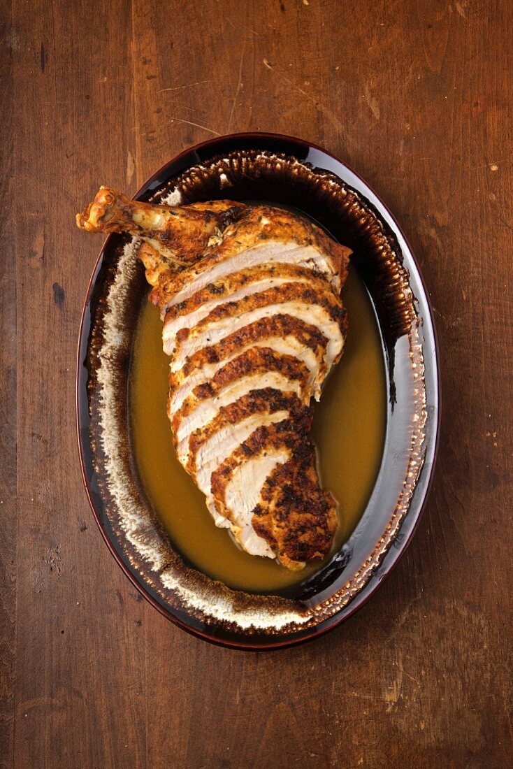 Turkey sliced with gravy on a rustic table