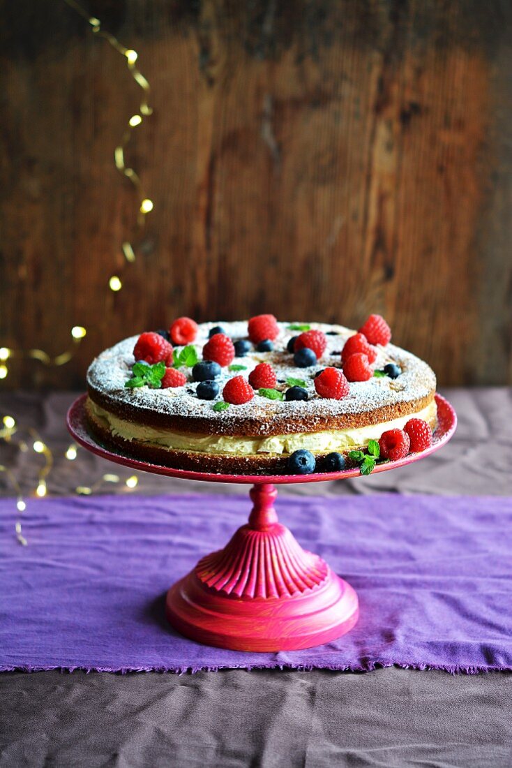 Biskuitkuchen mit Waldfrüchten und Creme auf einer Etagere