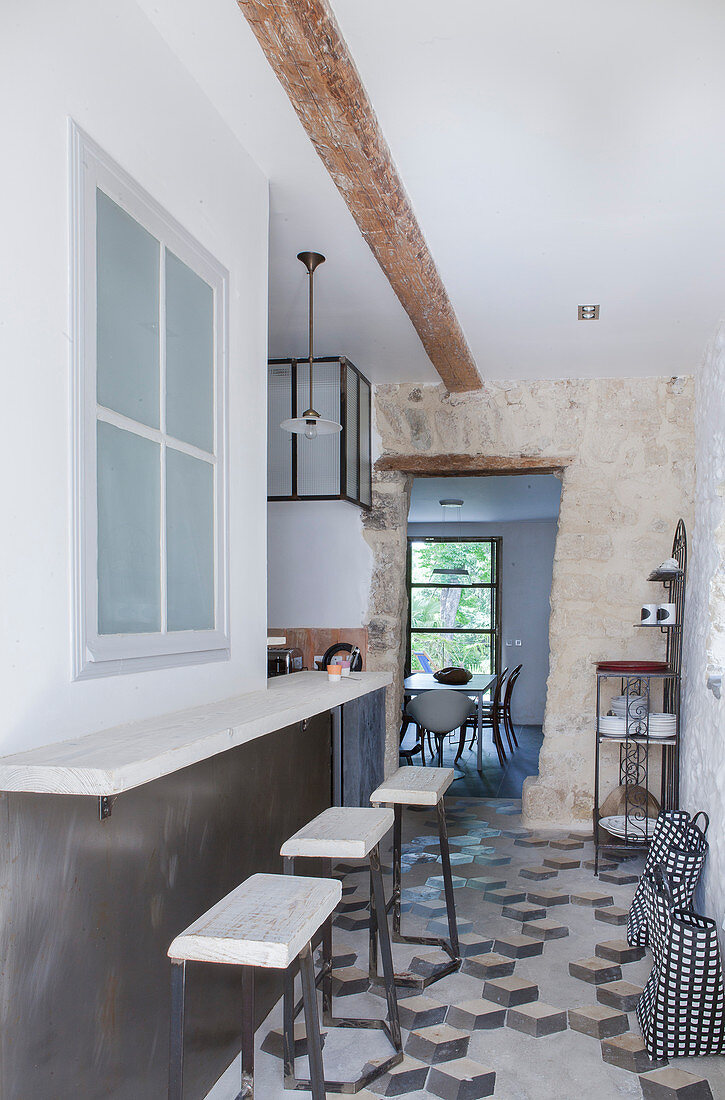 Counter and barstools in narrow hallway leading to kitchen