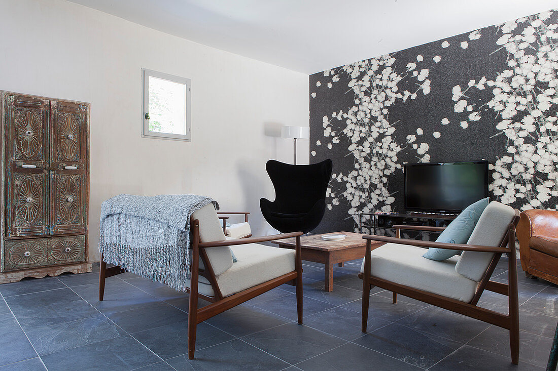 Scandinavian design classics in living room with patterned wallpaper on accent wall