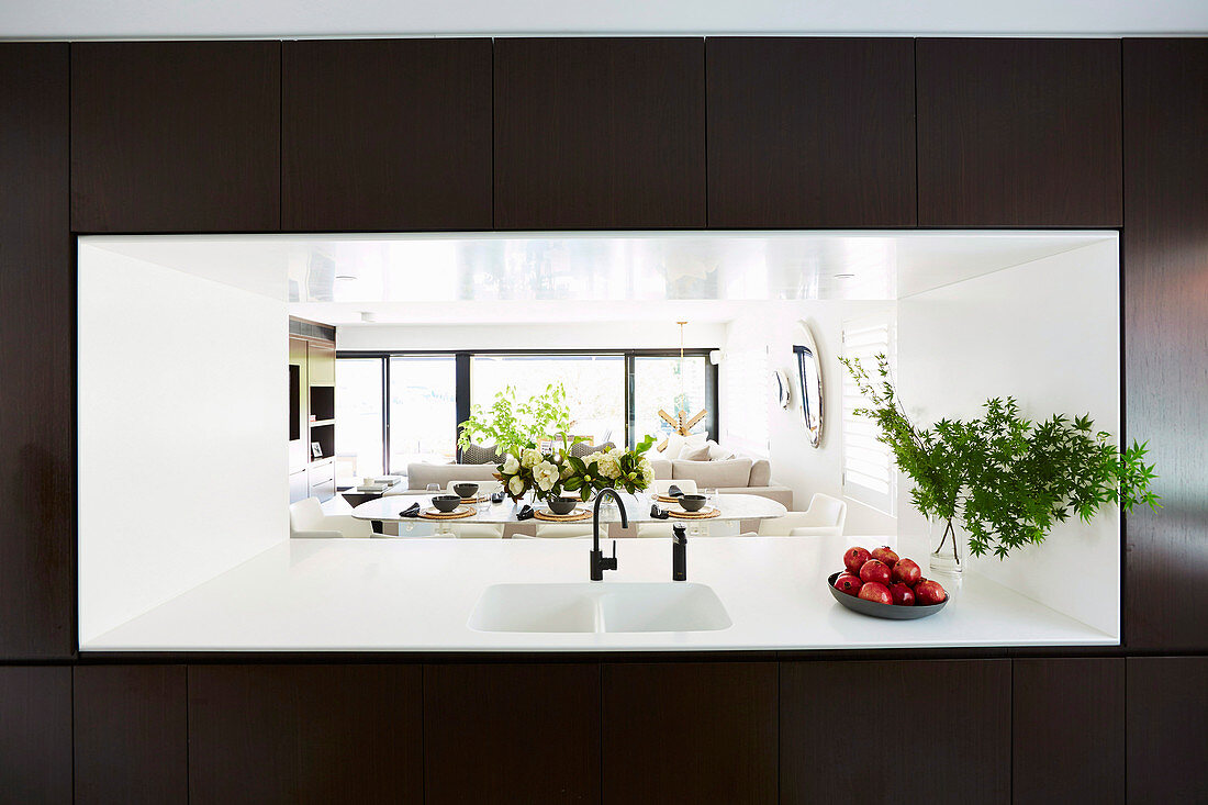 View through modern hatch with sink into the living and dining room