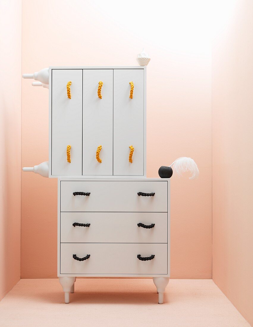 White chests of drawers against pink wall