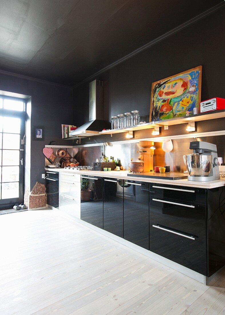 Schwarze Küche mit Hochglanzfronten und weißem Boden