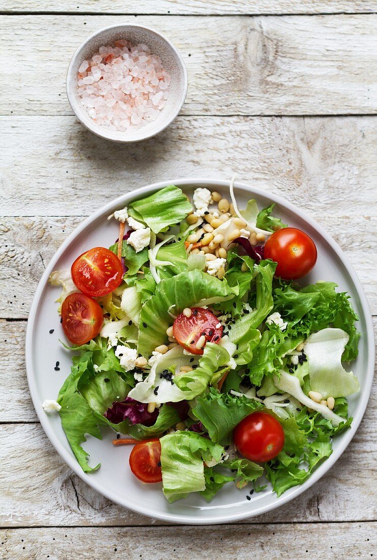 Mixed salad with tomatoes, goat's cheese, pine nuts and sesame