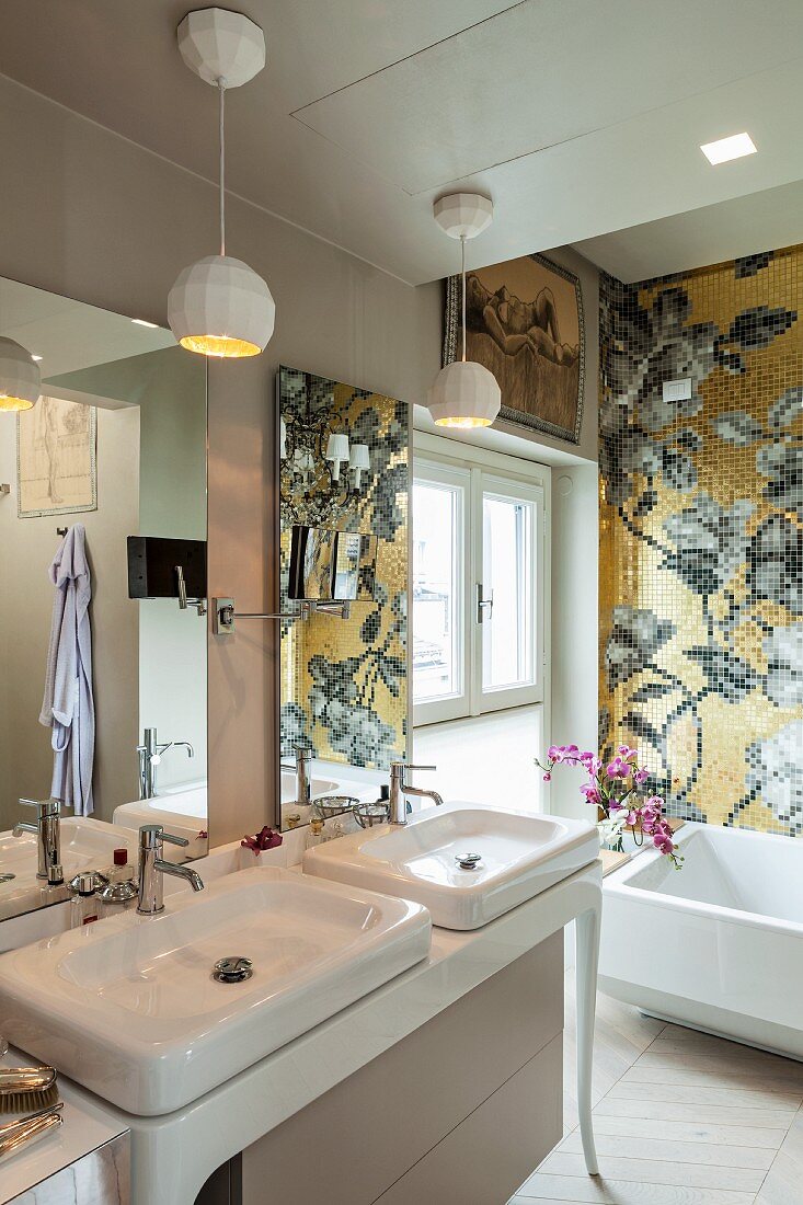 Goldenes Mosaik mit Blumenmotiv über der Wanne im luxuriösen Bad