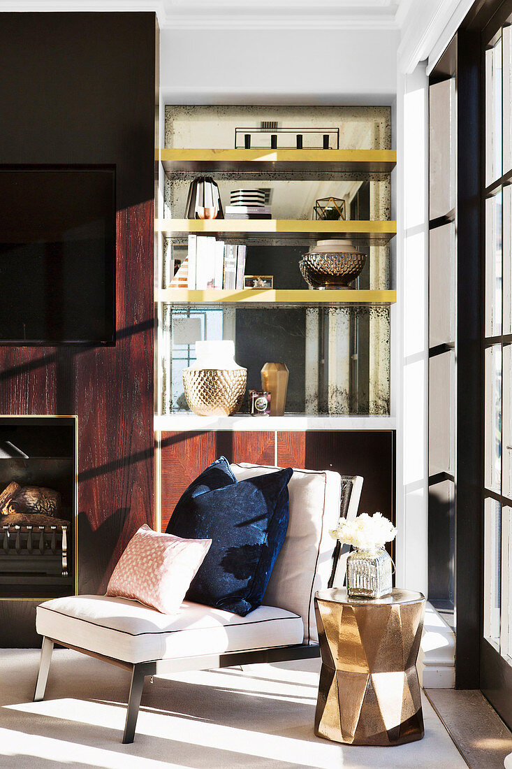 Armchairs and golden side table against elegant living room wall