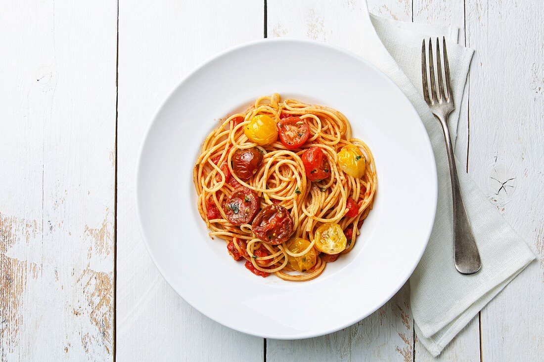 Spaghetti mit Tomatensauce auf weißem Teller (Aufsicht)