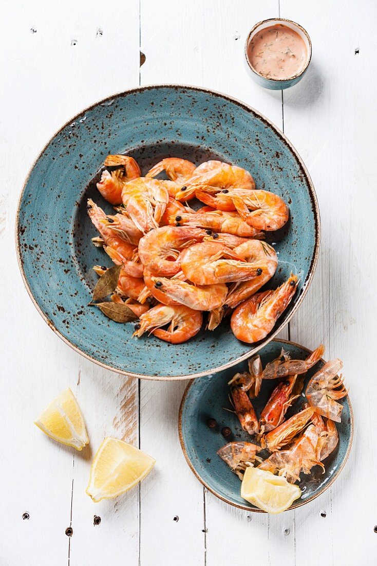 Prepared shrimps on blue plate on wooden background