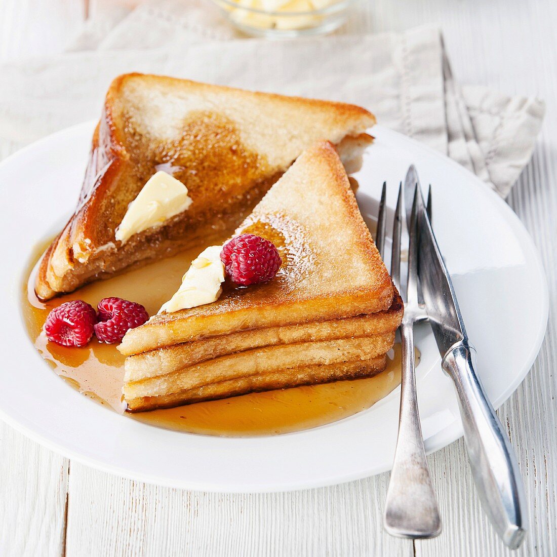 French toast with raspberries, maple syrup and butter