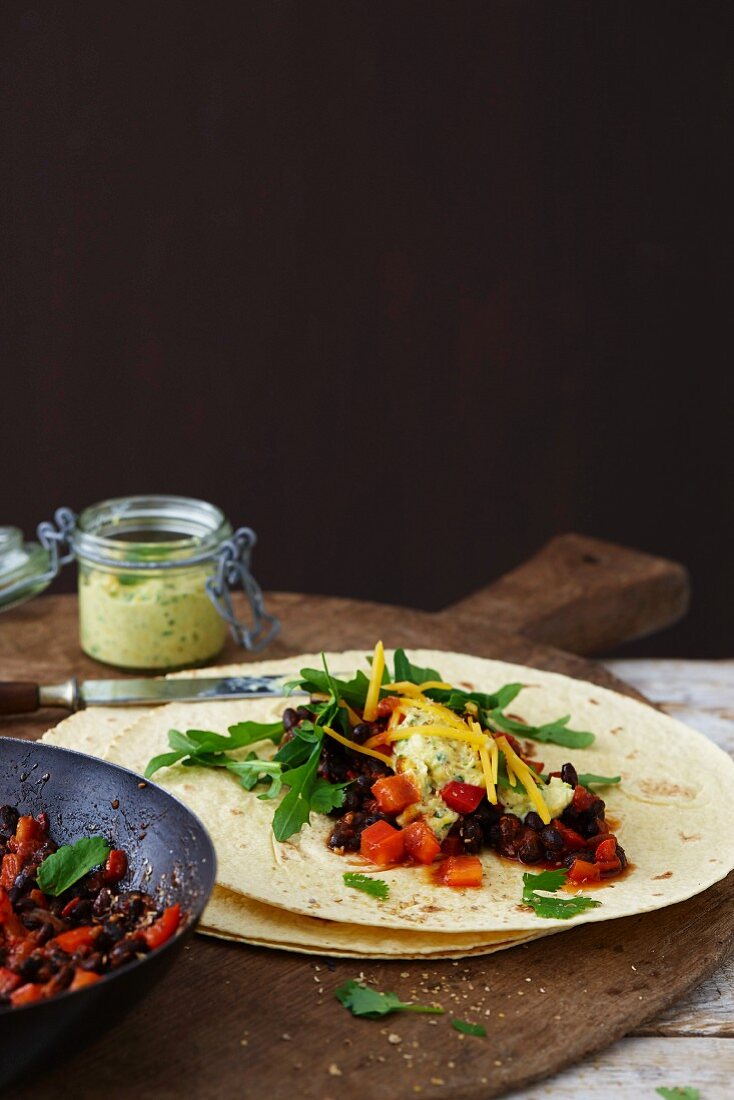 Bean burritos with rocket, cheese and a corn dip