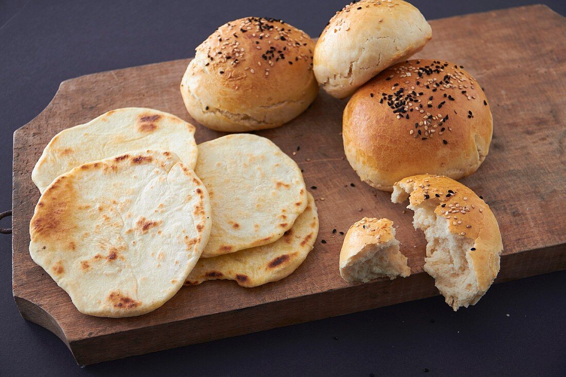 Burger buns and flatbread on a wooden board