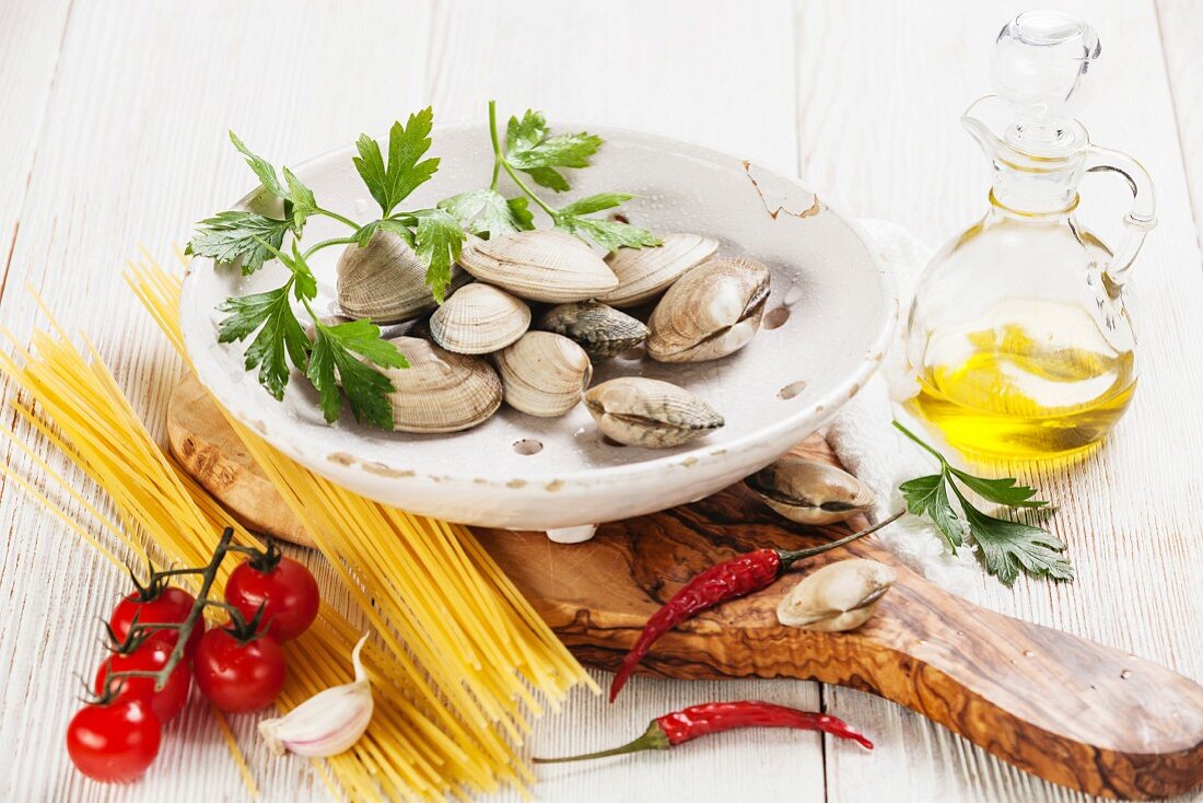 Ingredients for cooking spaghetti vongole Shells vongole, raw sapaghetti, parsley leaves, cherry tomatoes