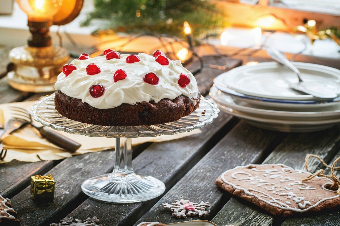 Weihnachtstisch mit Schokoladen-Kirsch-Torte und Zuckerplätzchen
