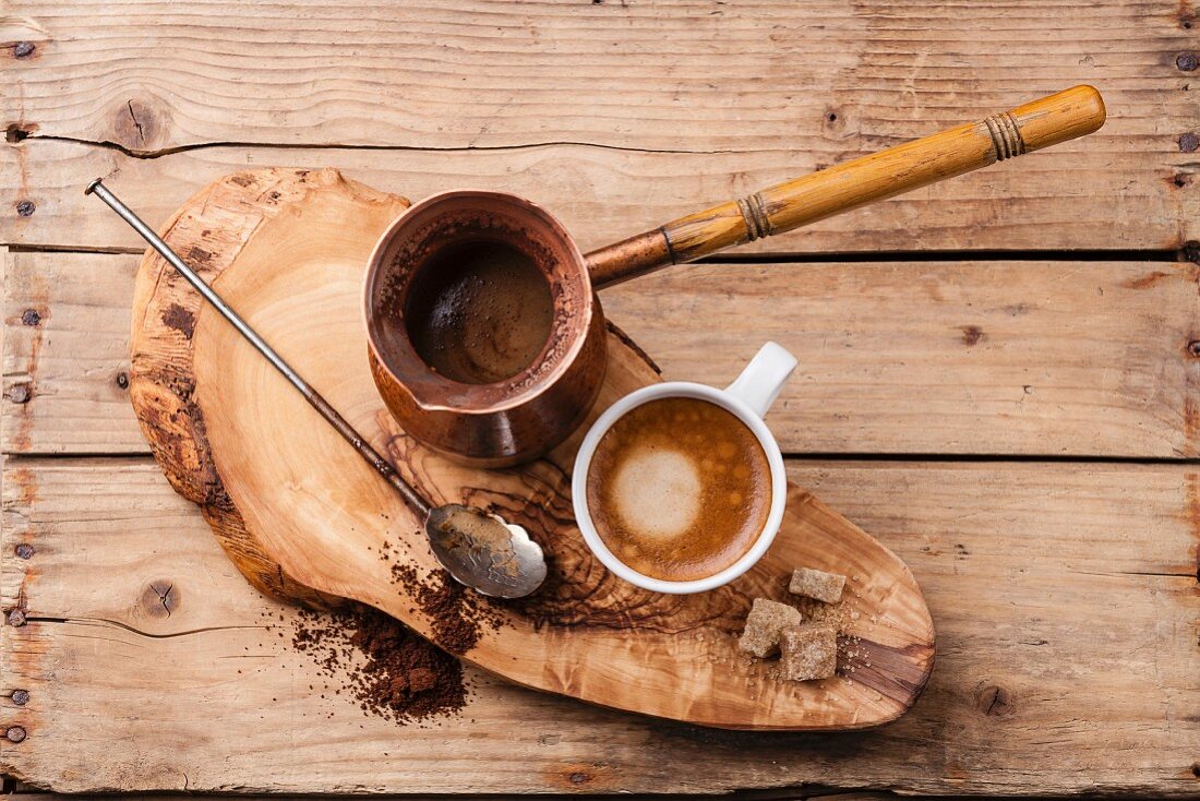 Türkischer Kaffee in Ibrik und Tasse auf rustikaler Baumscheibe