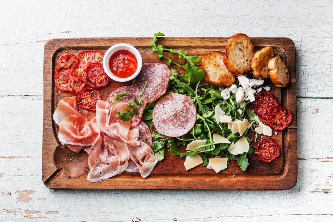 Cold meat plate and bread on wooden background
