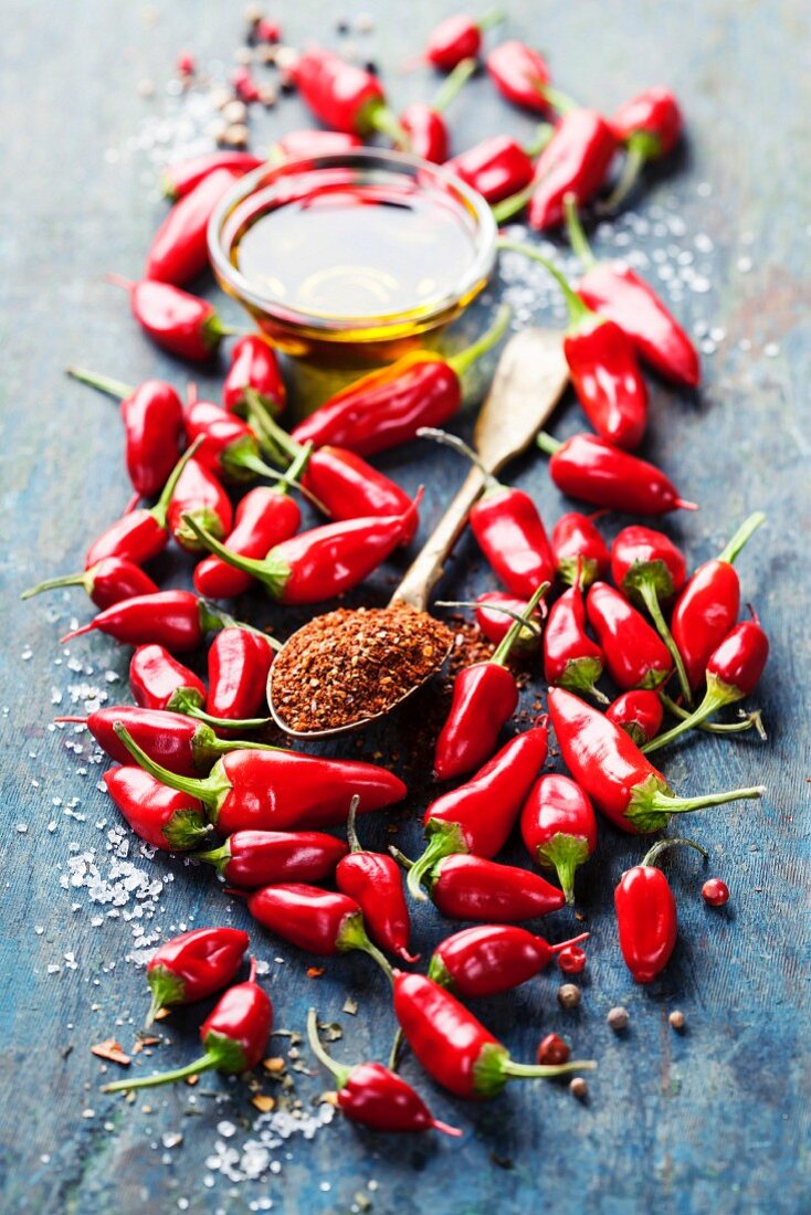 Red Hot Chili Peppers and olive oil over wooden background
