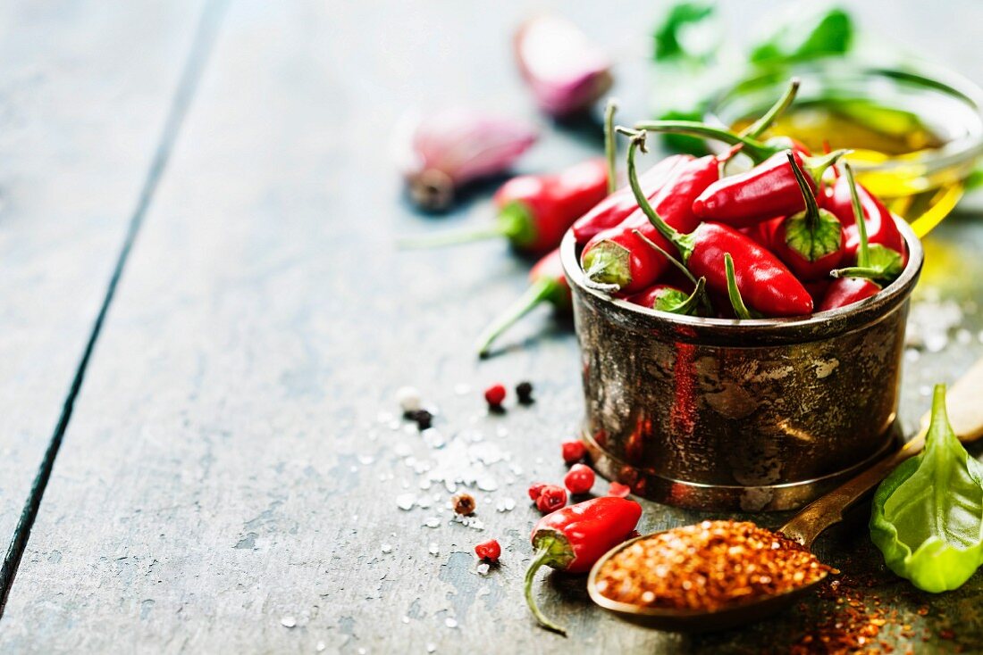 Red Hot Chili Peppers with herbs and spices over wooden background