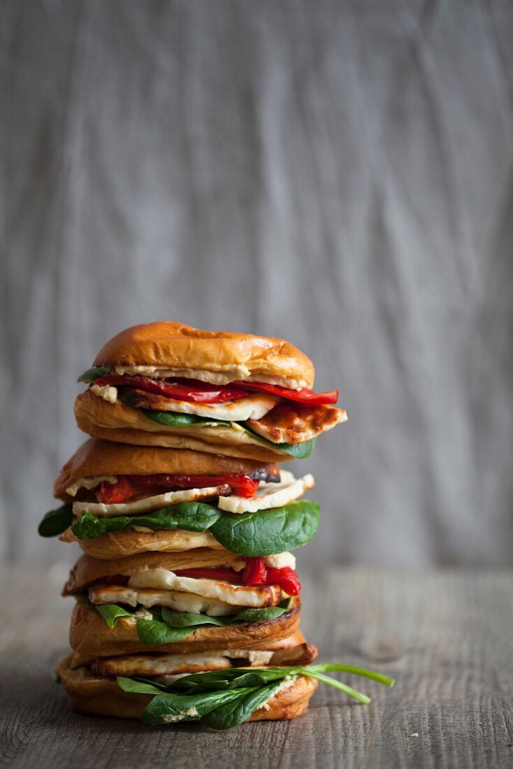 Brioche-Burger mit Halloumi, Hummus, Spinat und Paprika, gestapelt