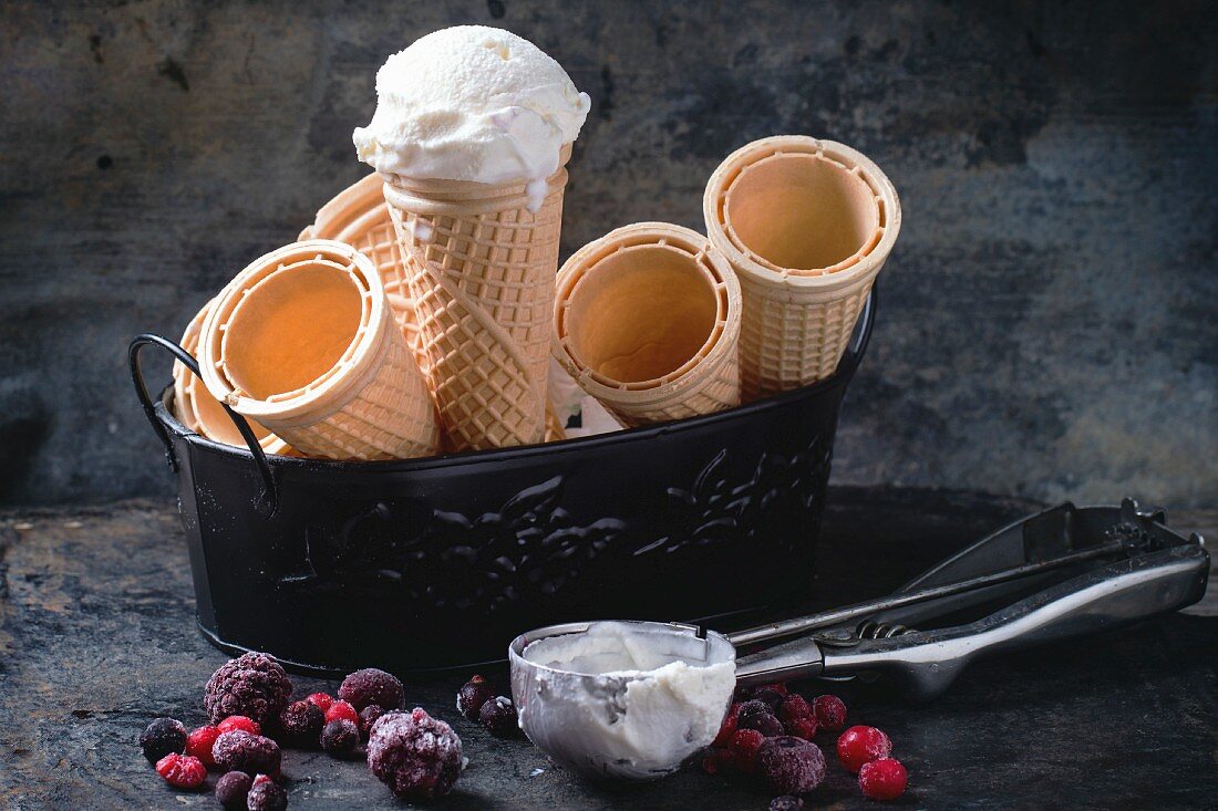 Vanilla ice cream in wafer cones and empty waffer cones