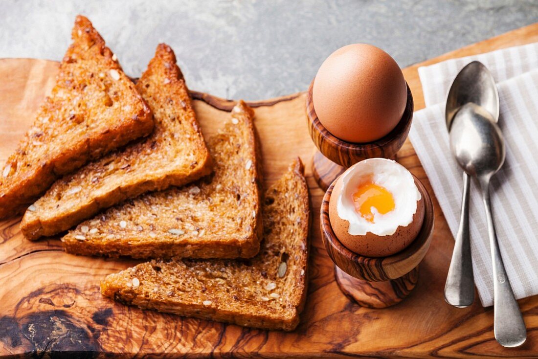 Boiled eggs for breakfast in olive wood egg cups