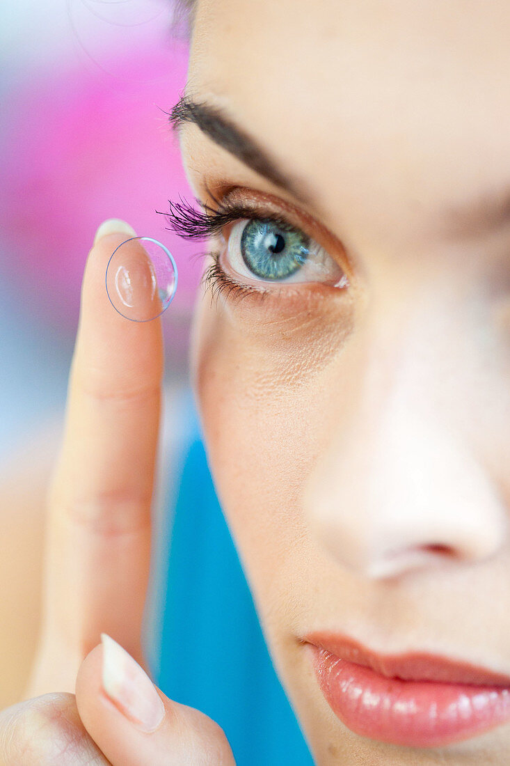 Woman applying contact lens