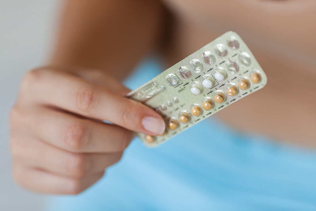 Woman holding contraceptive pills